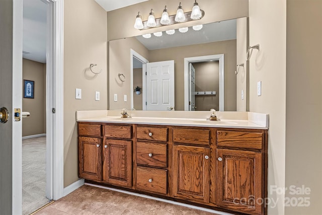 full bathroom featuring tile patterned floors, a sink, baseboards, and double vanity