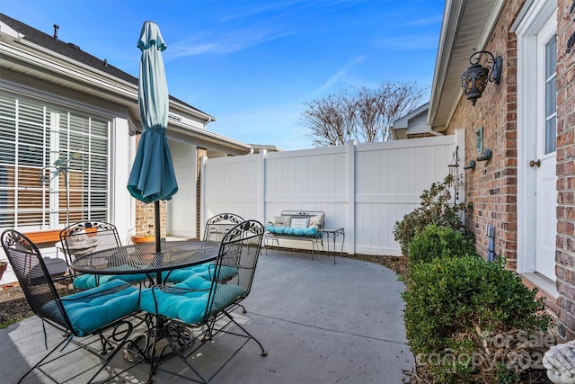 view of patio featuring outdoor dining space and fence