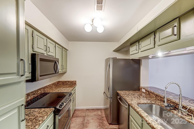 kitchen with stainless steel appliances, visible vents, green cabinets, a sink, and dark stone countertops