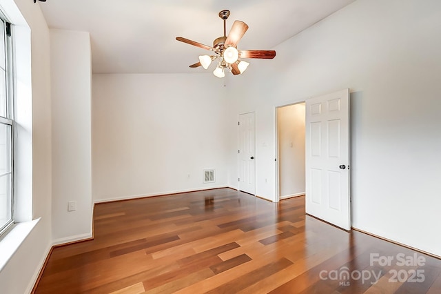 unfurnished bedroom with a ceiling fan, visible vents, baseboards, and wood finished floors