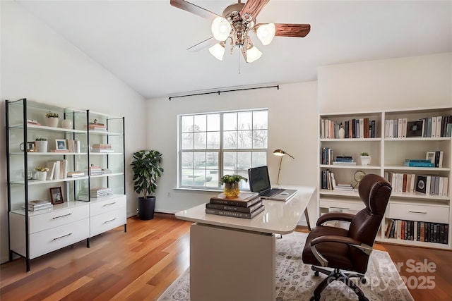 office space featuring a ceiling fan, light wood-type flooring, and vaulted ceiling