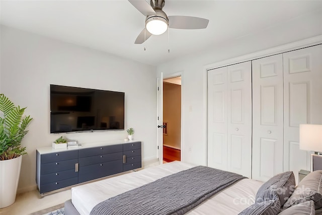 bedroom with a ceiling fan, a closet, and light carpet