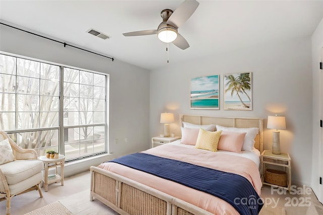 bedroom with light colored carpet, visible vents, and a ceiling fan