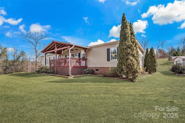 view of side of property featuring a lawn and a deck