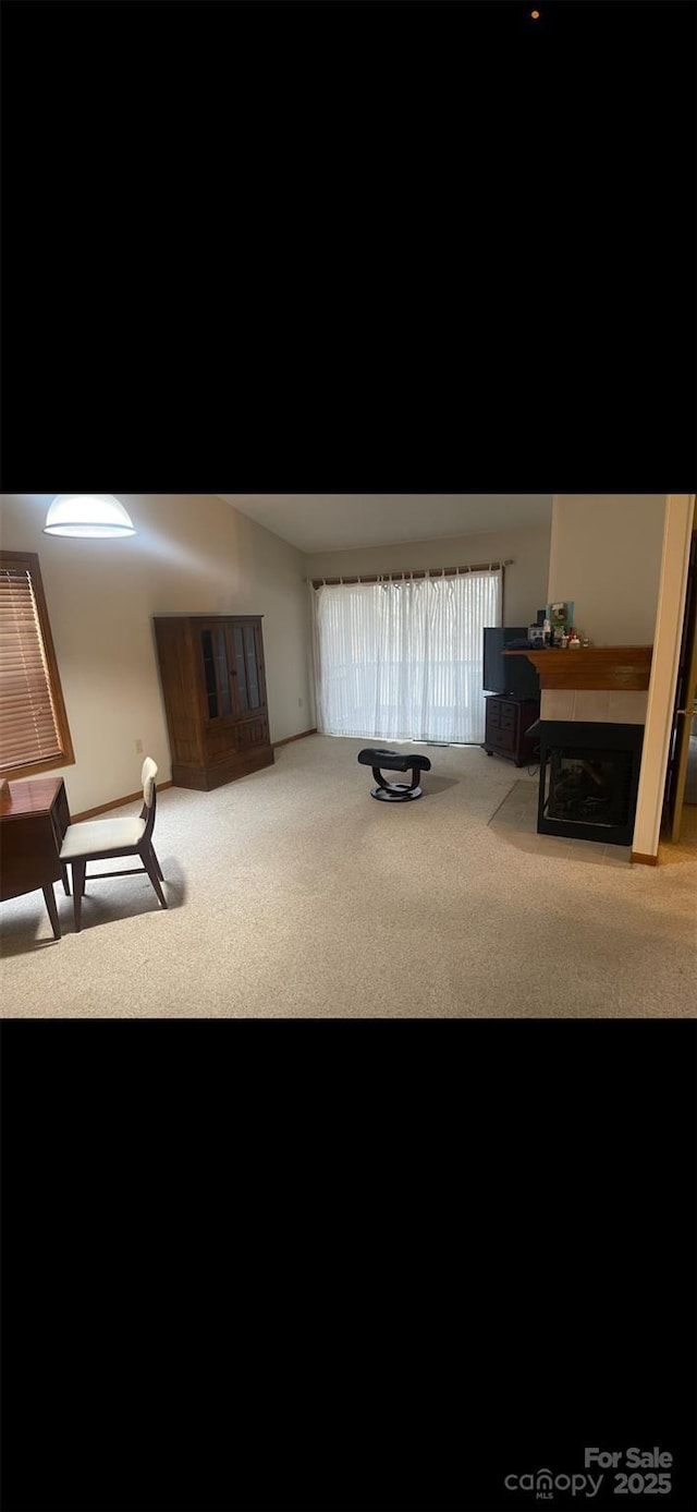 sitting room featuring a fireplace and carpet