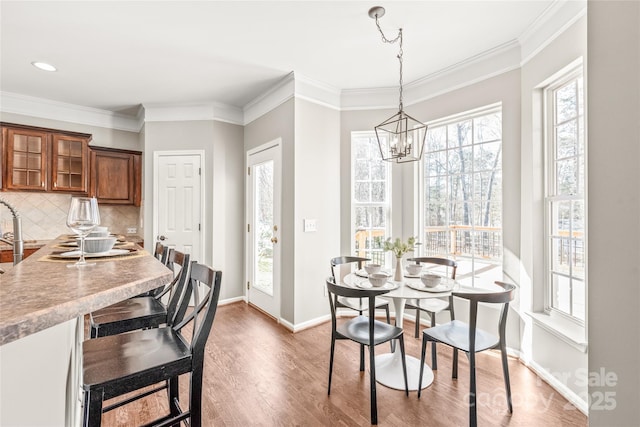 dining area featuring hardwood / wood-style floors, a chandelier, and crown molding