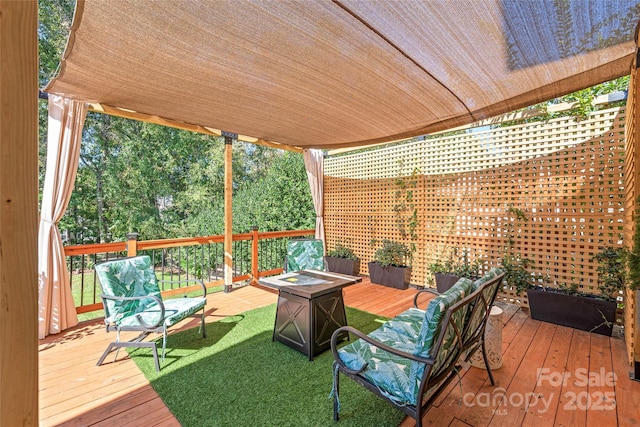 wooden deck with a fire pit and a lawn