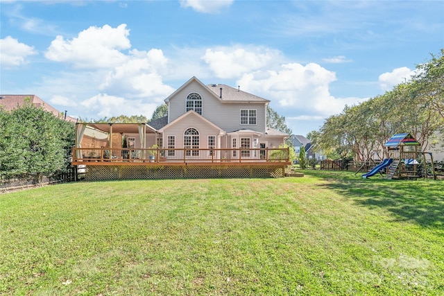 back of house with a playground, a yard, and a wooden deck