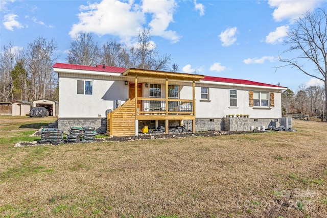 back of property with central AC unit, a shed, a wooden deck, and a lawn