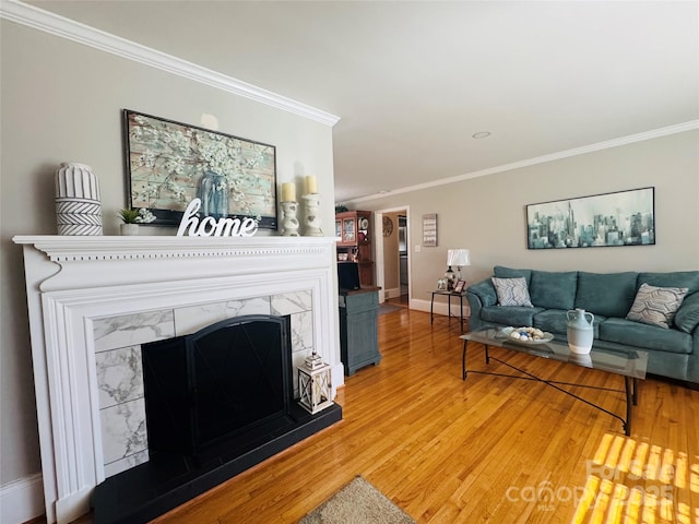 living room with crown molding, hardwood / wood-style floors, and a fireplace