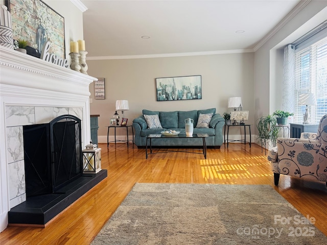 living room featuring crown molding, a premium fireplace, and hardwood / wood-style flooring