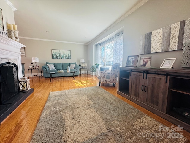 living room featuring crown molding, light wood-type flooring, and a fireplace