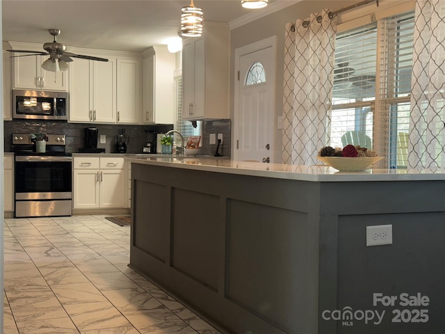 kitchen with white cabinetry, decorative backsplash, hanging light fixtures, ornamental molding, and stainless steel appliances