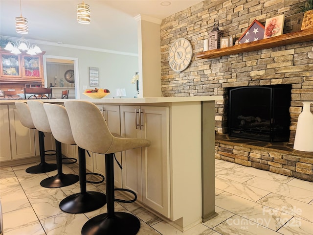 bar featuring pendant lighting, ornamental molding, and an inviting chandelier