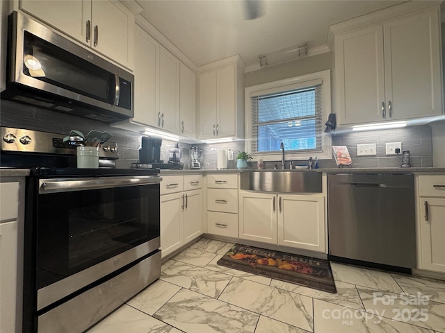 kitchen featuring white cabinetry, stainless steel appliances, sink, and decorative backsplash