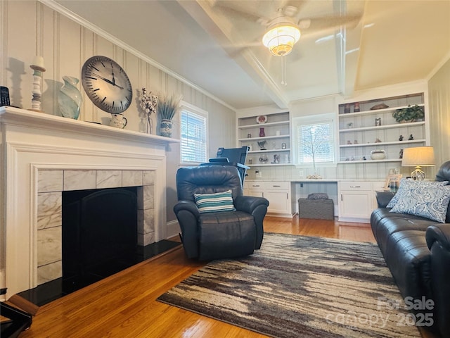 living area featuring light hardwood / wood-style flooring, built in desk, plenty of natural light, and ornamental molding