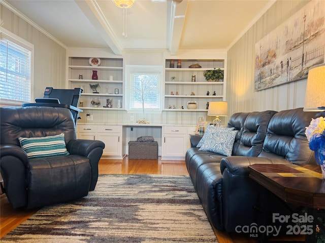 living room featuring built in desk, ornamental molding, built in features, beam ceiling, and light hardwood / wood-style floors