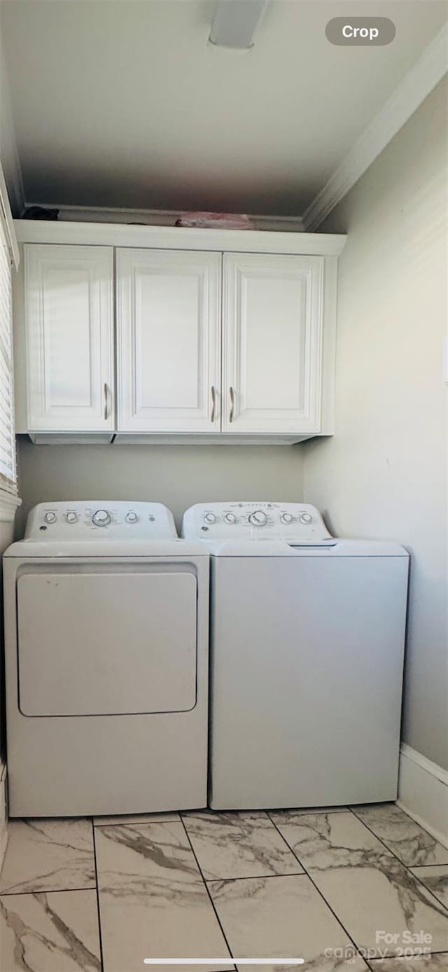 laundry area with cabinets, ornamental molding, and washer and clothes dryer