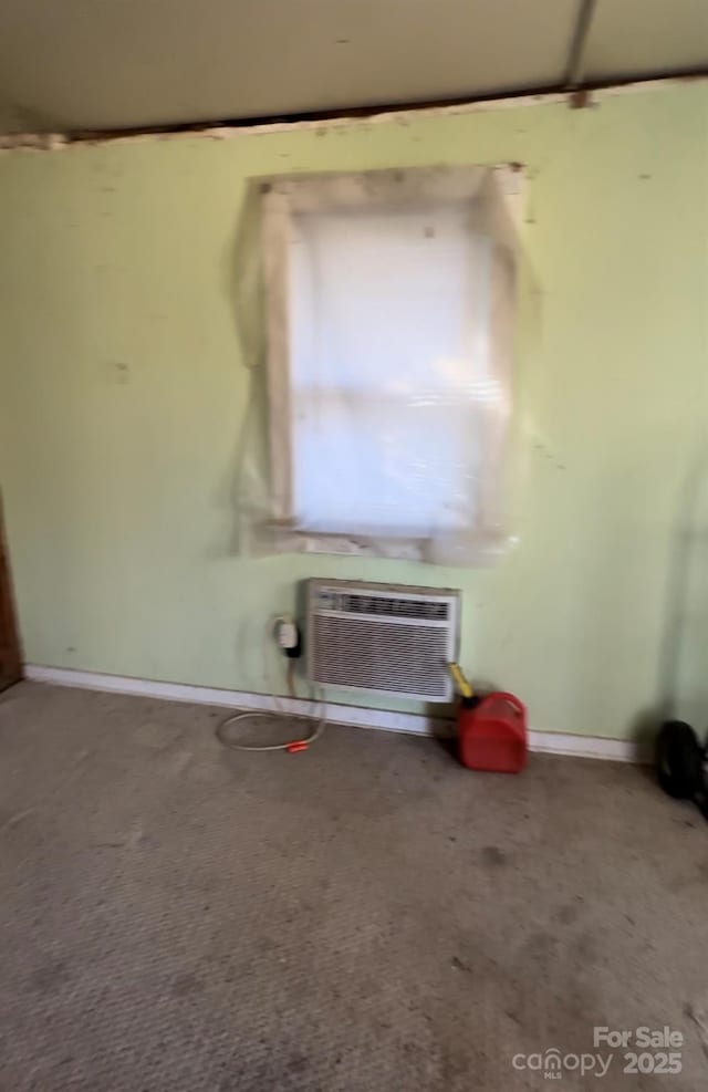 carpeted empty room featuring an AC wall unit