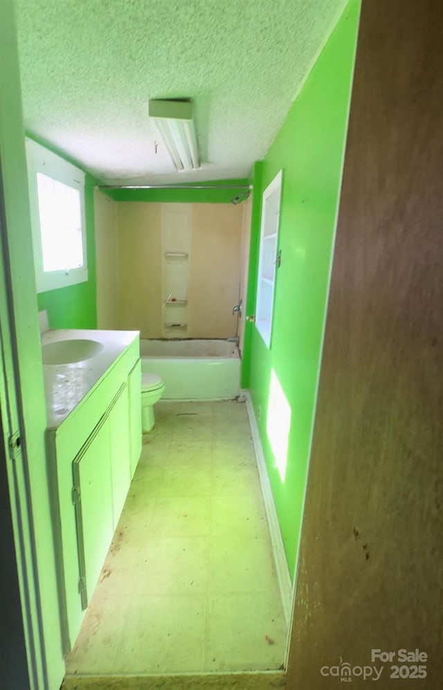 full bathroom with vanity, bathtub / shower combination, a textured ceiling, and toilet