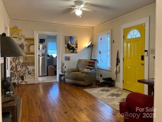 entrance foyer featuring hardwood / wood-style floors, a healthy amount of sunlight, ceiling fan, and crown molding