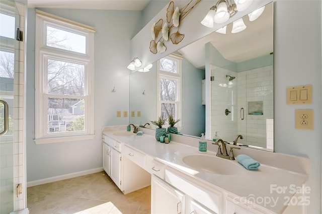 bathroom featuring a stall shower, a healthy amount of sunlight, a sink, and double vanity