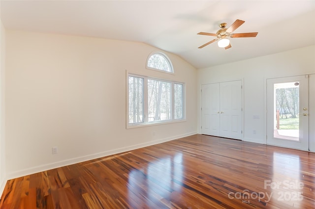 empty room with lofted ceiling, ceiling fan, baseboards, and wood finished floors