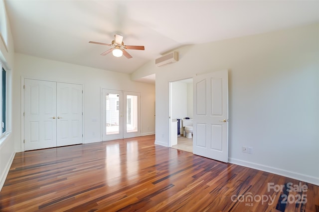 unfurnished bedroom featuring french doors, dark wood-style flooring, a closet, a wall mounted AC, and vaulted ceiling