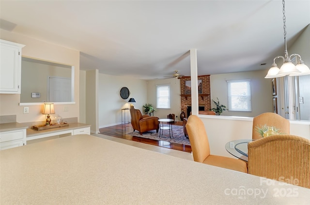 living room featuring ceiling fan, a wealth of natural light, a fireplace, and wood finished floors