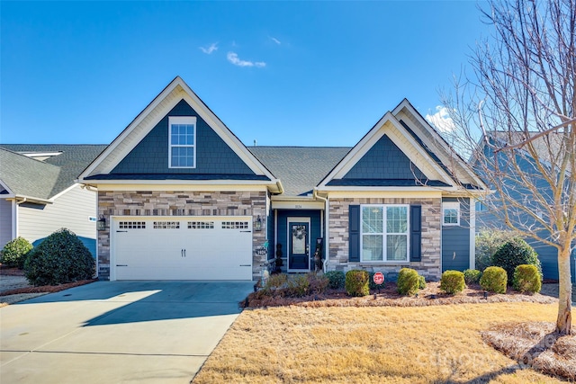 craftsman house with concrete driveway, an attached garage, stone siding, and a front yard