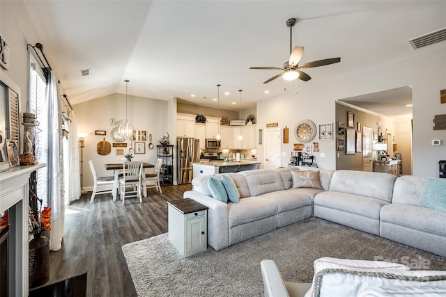 living room with dark wood finished floors, vaulted ceiling, visible vents, and ceiling fan with notable chandelier