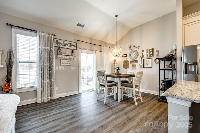 dining space with dark wood-style floors, vaulted ceiling, visible vents, baseboards, and a chandelier