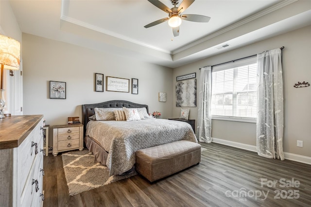 bedroom featuring crown molding, visible vents, dark wood-style floors, and a tray ceiling