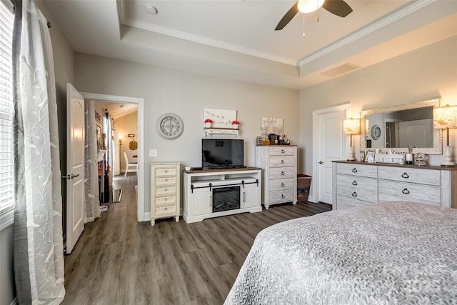 bedroom featuring dark wood-style floors, visible vents, crown molding, baseboards, and ceiling fan