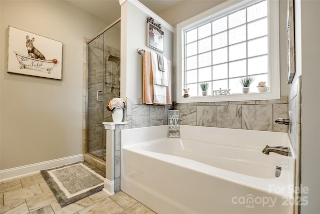 full bath featuring baseboards, a garden tub, and a stall shower