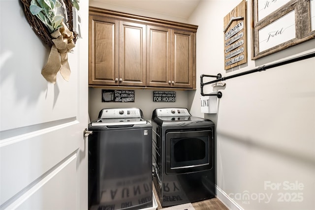 washroom with cabinet space, wood finished floors, washing machine and clothes dryer, and baseboards