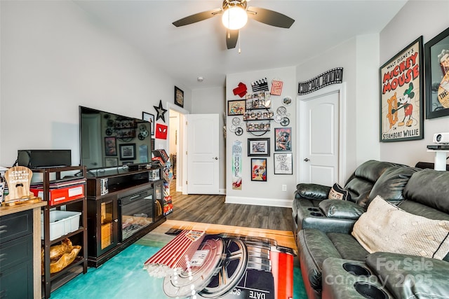 living area with ceiling fan, baseboards, and wood finished floors