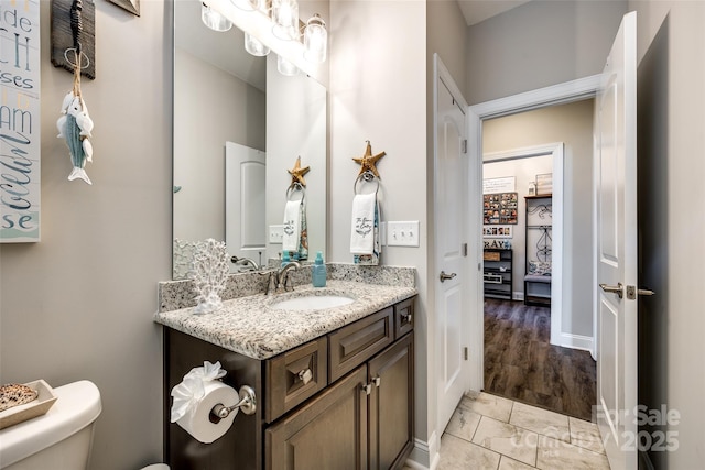 bathroom featuring marble finish floor, baseboards, toilet, and vanity