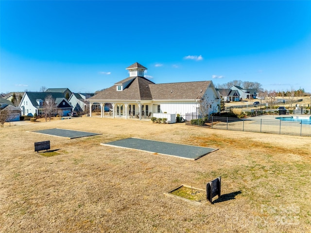 rear view of house with a patio area, fence, and a yard