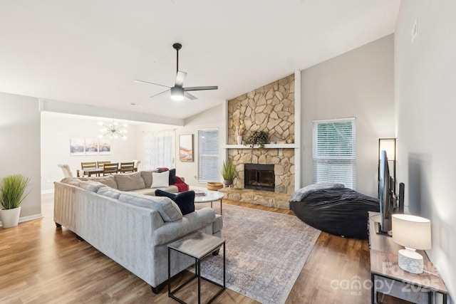 living area with a fireplace, lofted ceiling, a ceiling fan, wood finished floors, and baseboards