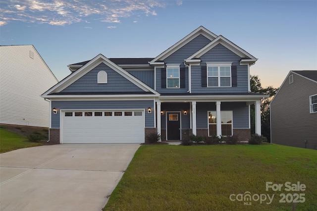 craftsman-style home with brick siding, covered porch, an attached garage, a front yard, and driveway