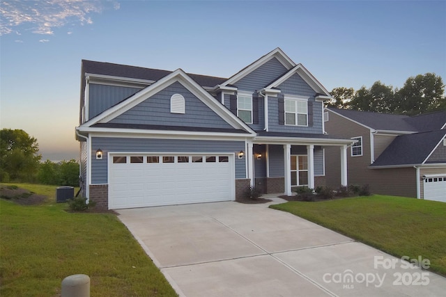 craftsman-style house featuring driveway, a garage, brick siding, central AC, and a front yard