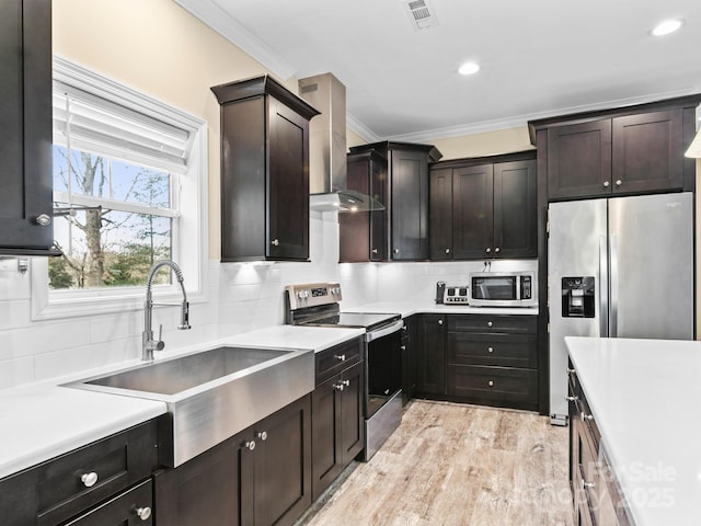 35 Dawson Steele Ct, Asheville, NC 28803 - kitchen featuring stainless steel appliances, ornamental molding, wall chimney exhaust hood, backsplash, and light countertops