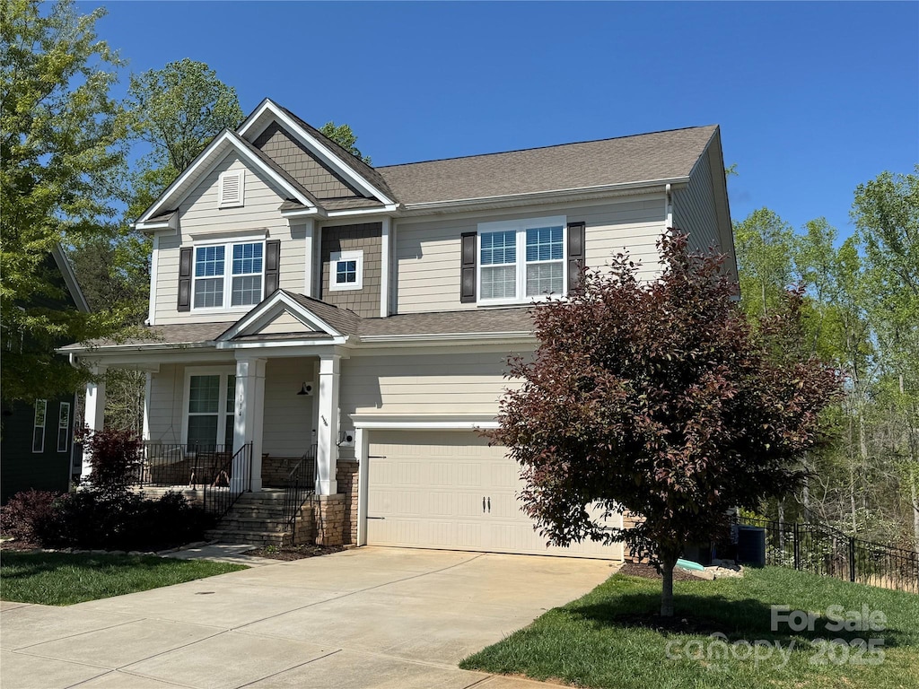 114 Tomahawk Dr, Mooresville, NC 28117 - craftsman-style home with concrete driveway, an attached garage, and covered porch