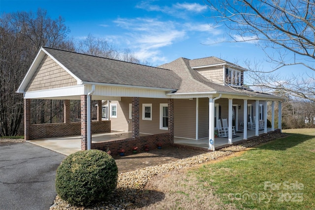 view of property exterior with a carport, a porch, and a lawn