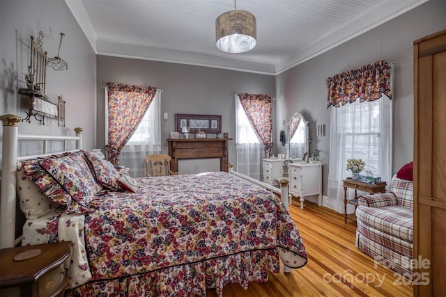 bedroom featuring ornamental molding and hardwood / wood-style floors