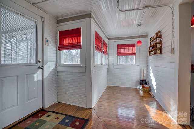 foyer featuring hardwood / wood-style floors, plenty of natural light, and brick wall