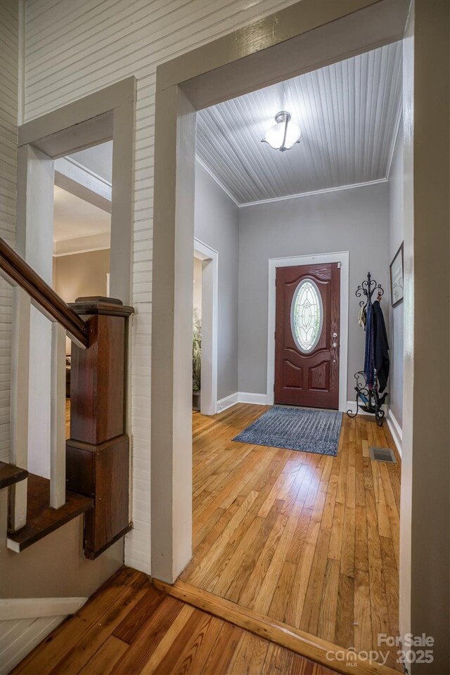 foyer with ornamental molding and hardwood / wood-style flooring