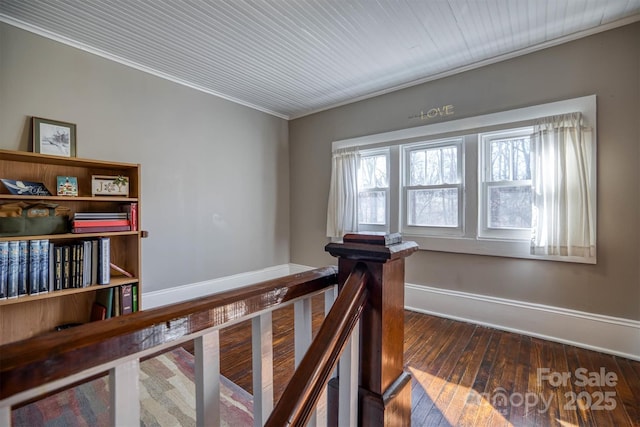 stairs with ornamental molding and hardwood / wood-style floors