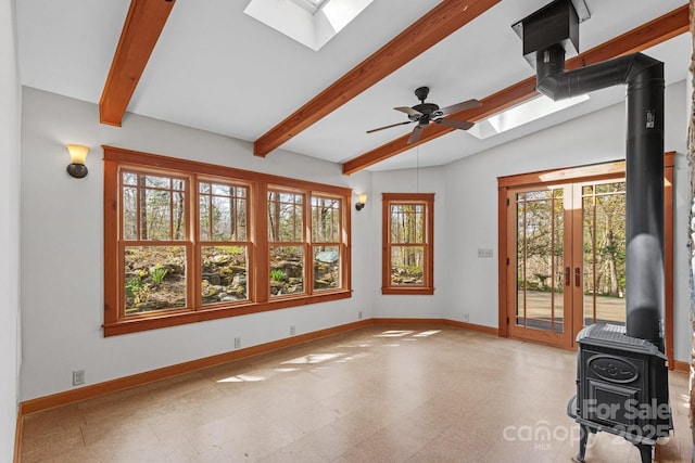 14 Woods Rd, Fairview, NC 28730 - unfurnished living room with a skylight, a wood stove, beam ceiling, tile patterned floors, and a ceiling fan